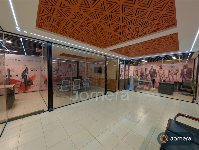 Open office floor with frameless glass partitions, black steel frames and CNC-cut terracotta ceiling panels